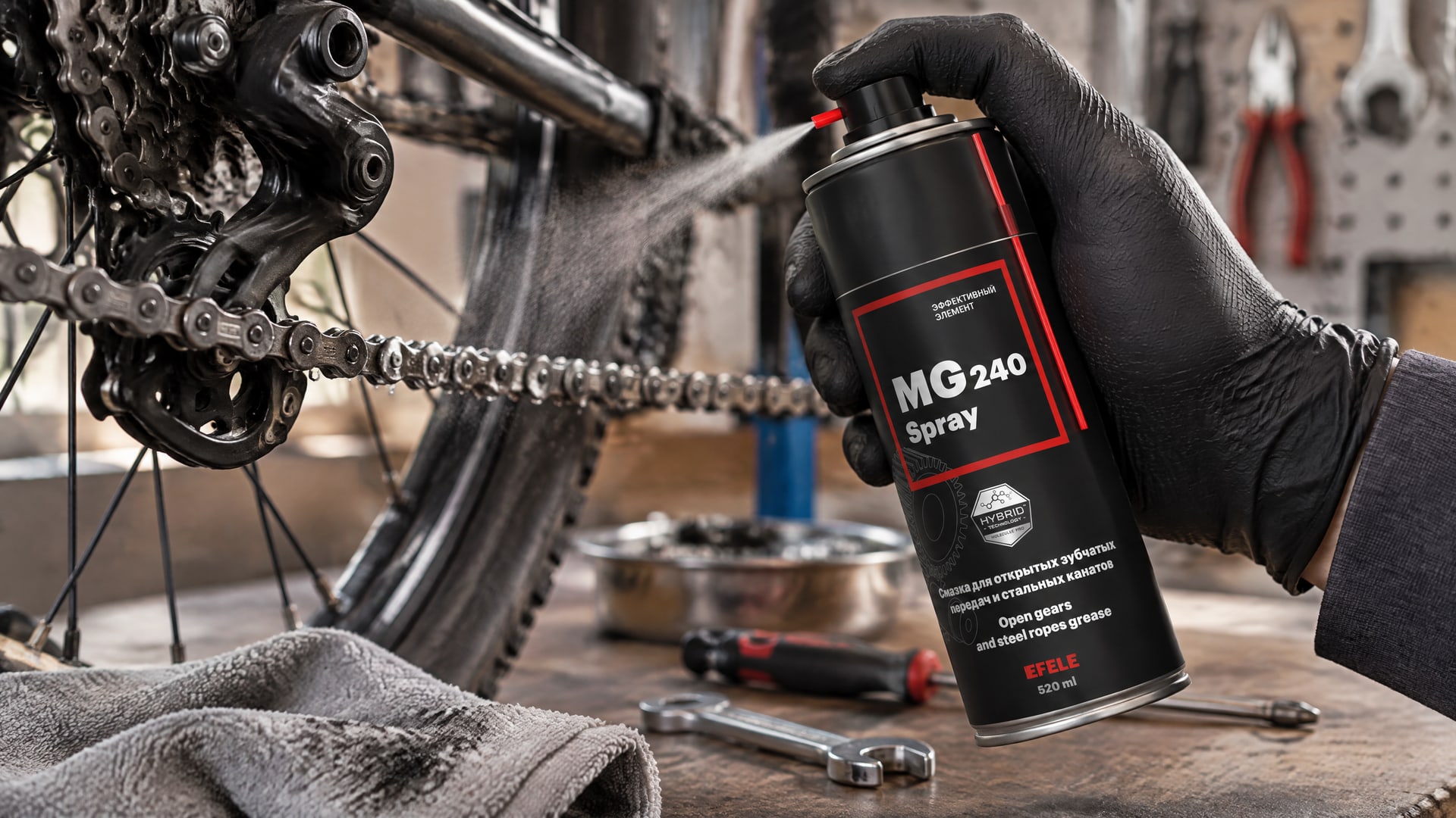 Рука в перчатке распыляет EFELE MG-240 Spray, смазку с дисульфидом молибдена.